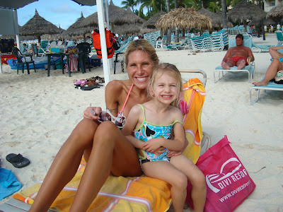 Woman and child in bathing suits sitting on beach lounger