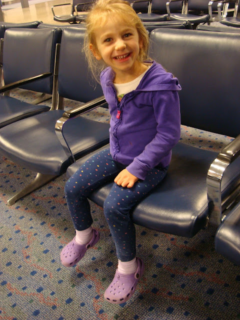 Young girl sitting on chair at airport
