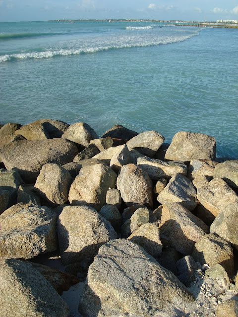 Looking over pile of rocks into ocean