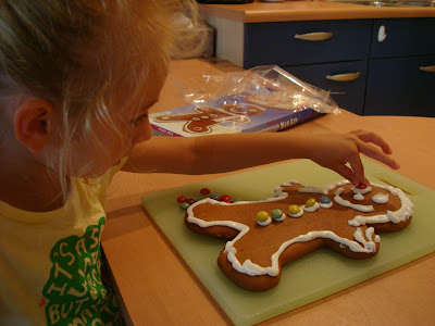 Young girl putting on candy eyes on gingerbread man