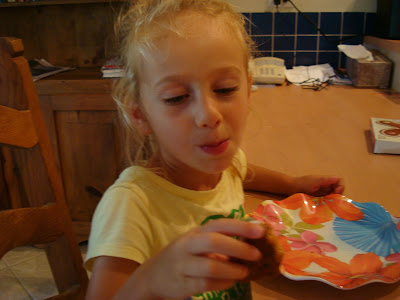 Young girl with mouthful holding portion of gingerbread man