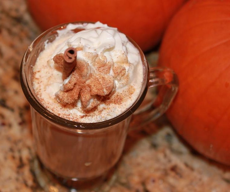 a delicious spiced coffee made with pumpkin in a slow cooker topped with whipped cream cinnamon and sugar called a pumpkin spiced latte