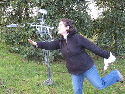 Lola posing with metal sculpture of disc golfer