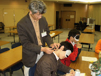 安全な筒を使って参加者にお灸をすえる講師