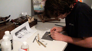 Noferin at work in studio. Carving a lino print.