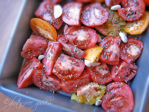 A pan of fresh cut tomatoes and garlic ready for roasting.