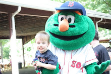 Nathan holding his green monster while being held by the Green Monster of the Red Sox