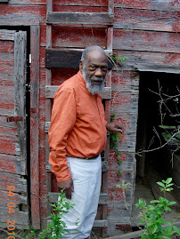 Roy next to the mouldering barn on the 20 acres surrounding their house