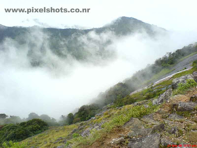 mist in munnar covering the mountains,a scenery of munnar mountains in mist photographed from rajamala munnar kerala