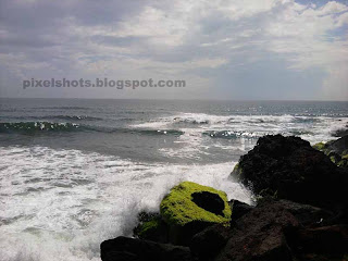 sea waves flowing over beach rocks,rough strong beach waves hitting sea side rocks,varkala waves and rocks photos