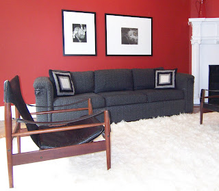 red contemporary living room with black and white artwork Swedish safari chair white Flokati rug