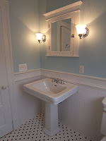 bathroom with pedestal sink light blue walls Restoration Hardware wall sconces black and white tile floor