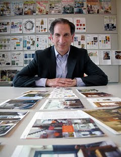A man surrounded by magazine layout pages