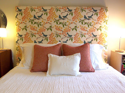 orange and white monogrammed accent pillows on bed
