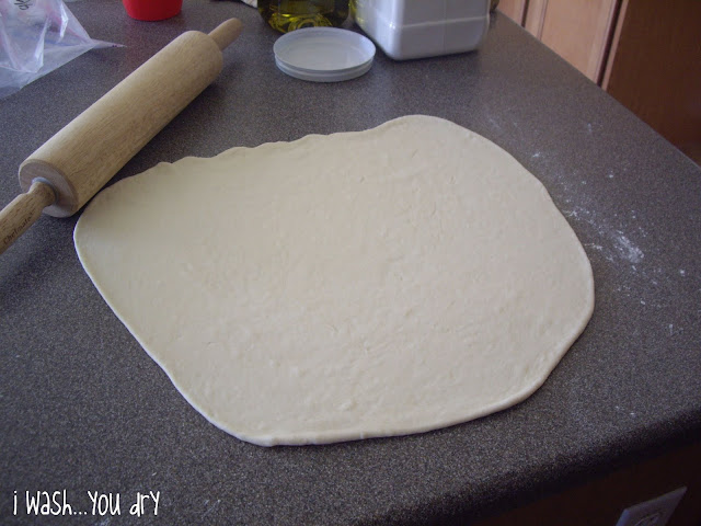 Pizza dough rolled out non a counter. 