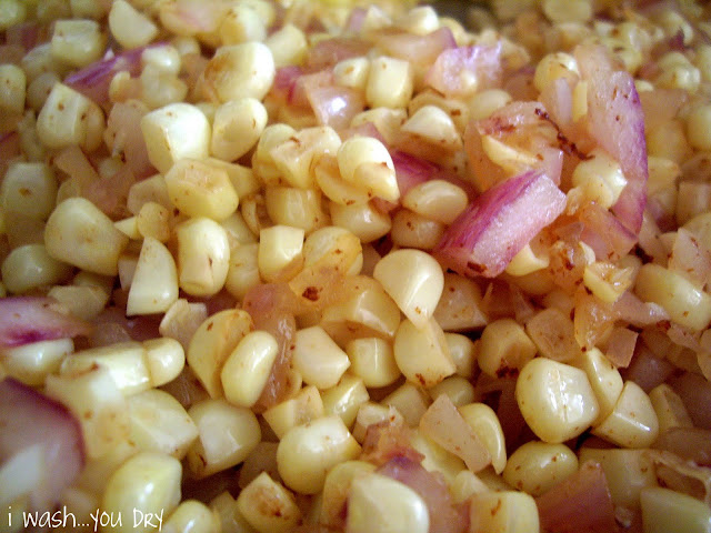 A close up of cooked corn and diced onions.