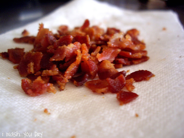 A close up of a pile of chopped bacon pieces on a paper towel. 
