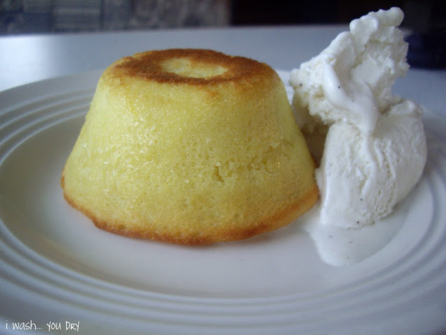 An upside down mini cake on a plate with a side of vanilla ice cream. 