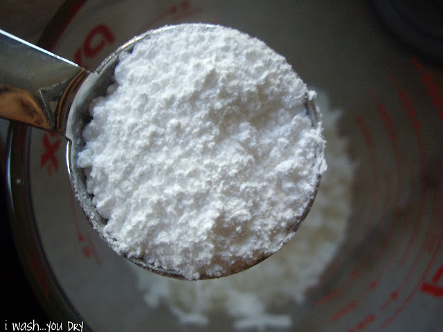 A close up of measuring cup of powdered sugar.