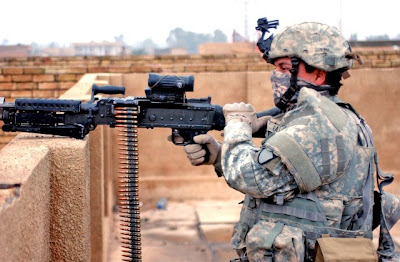 U.S. Army Pfc. Pedro Rangel provides security with an M240B machine gun from a rooftop while fellow soldiers begin work on building the new combat out post in Ghazaliya, Iraq, Jan. 14, 2007. Rangel is with Charlie Company, 2nd Battalion, 12th Cavalry Regiment, 1st Cavalry Division. U.S. Army photo by Sgt. Martin K. Newton.  