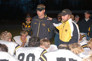 Cpl. James Hogan (center right, wearing baseball cap), a native of Superior, Wisc., speaks to the Northwestern High School Tigers football team, also of Superior, Wis., during his last season coaching in 2004. Hogan now serves with Company A, 4th Battalion, 31st Infantry Regiment, 2nd Brigade Combat Team, 10th Mountain Division (Light Infantry), out of Fort Drum, N.Y., and coaches Iraqi soldiers on infantry skills. Courtesy photo.