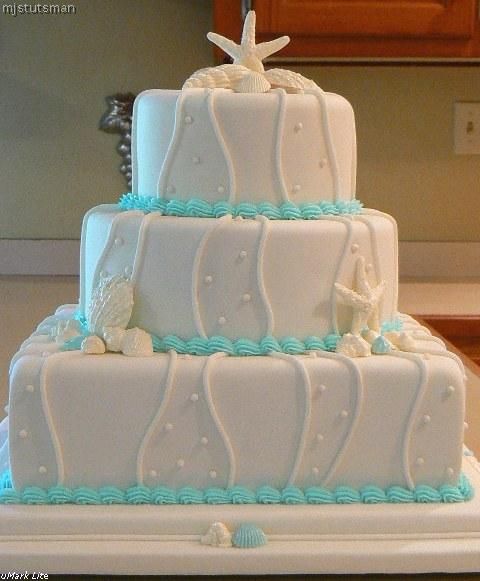 Stunning three tier white wedding cake with white seashells and tiffany blue