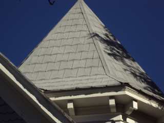 Witch hat decoration on embossed tin shingle porch roof