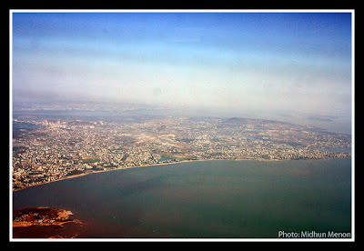arial photograph of mumbai city scape with coastal line visible taken from aircraft window