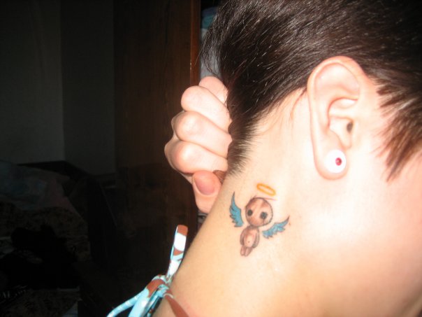 Small angel tattoo behind ear.