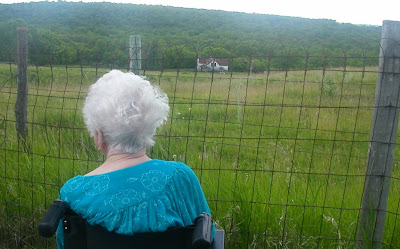 Mom looking down on her childhood home from the churchyard