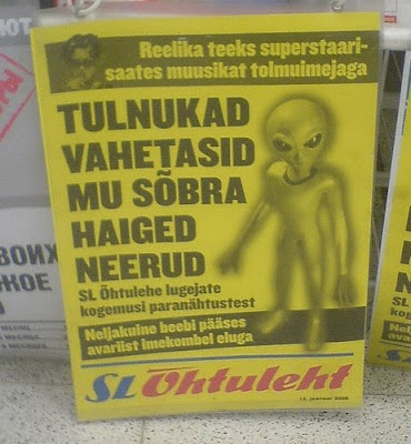 foreign tabloid newspaper with picture of space alien on it