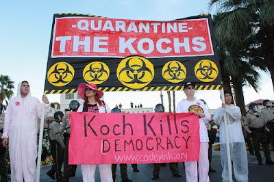 protest with two banners, Quarantine the Kochs and Koch Kills Democracy www.codepink.org