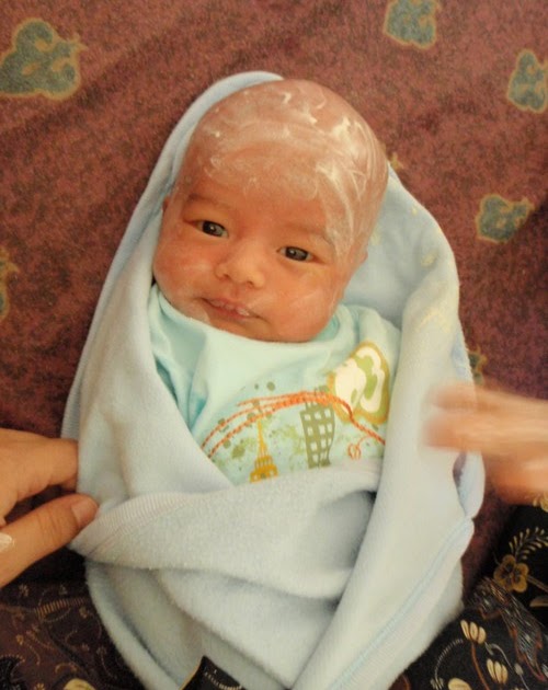 MyISLAM Rubbing the baby's shaved head with saffron