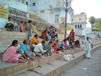 A group of pilgrims performing a puja assisted by a Panda at the Pushkar Lake
