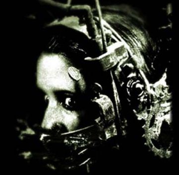 Imagem em preto e branco do rosto de uma mulher que usa um aparato mecânico que envolve as laterais e o topo de sua cabeça, bem como parte de sua face, tampando sua boca..