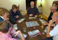 The players look at the RoboRally board, amazed at the chaos within a simple game