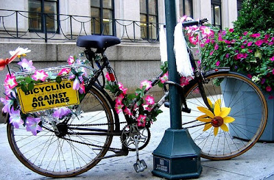 Image of flower decorated bicycle with bicycling against oil wars sign