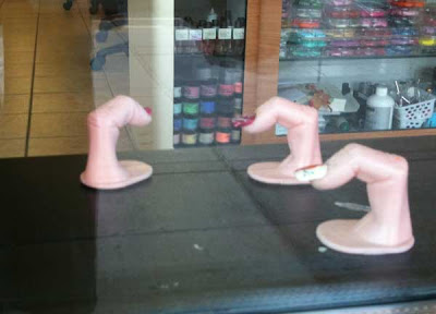 Plastic fingers on stands with protruding fingernails, sitting on a retail window sill