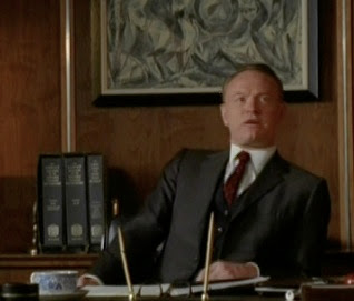 Mad Men's Lane Pryce at his desk with the three-volume OED in the background