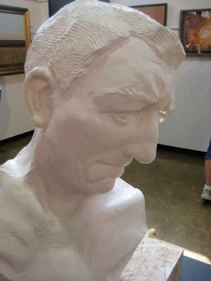 White plaster sculpture of a man's head, looking downward