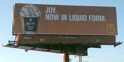 McDonald's billboard with photo of beautiful whipped cream and caramel topped paper cup and headline Joy. Now in Liquid Form