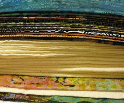 Stack of fabrics and batting to be quilted