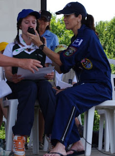 photo by Kim Mackrael, Guelph Mercury. Megan Sumner, a guide from Whitehorse, Yukon, is assisted Friday at Guelph Lake by Lori McFarlane of the space station amateur radio program as she asks astronaut Doug Wheelock a question.