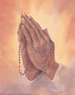 Cross with rosary beads in the hands of praying man photo