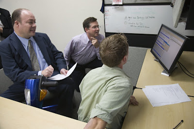 Tracy Justesen and Jim Fruchterman getting computer software demo from Paddy Sullivan