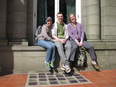Color photo of Renee, Brian and Anna on the window ledge of a bay window at Pittock Mansion museum, Portland, Oregon. Automatic timer photograph by Renee Hartig.