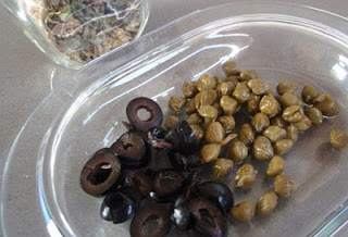 alcaparras y aceitunas negras en la elaboración de espaguetis a la putanesca