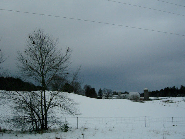 Snow-covered field in New Hampshire with a house and silo.
