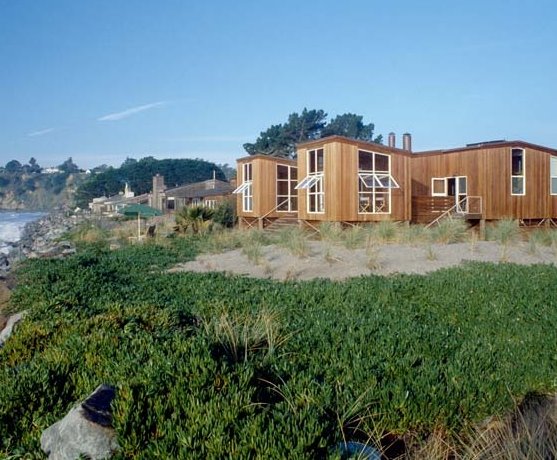 Vista en perspectiva donde se advierten los retiros Residencia de madera en la playa en California