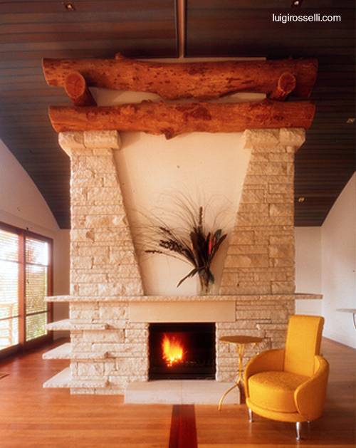 Arquitectura de Casas: Chimenea de piedra y troncos rústicos